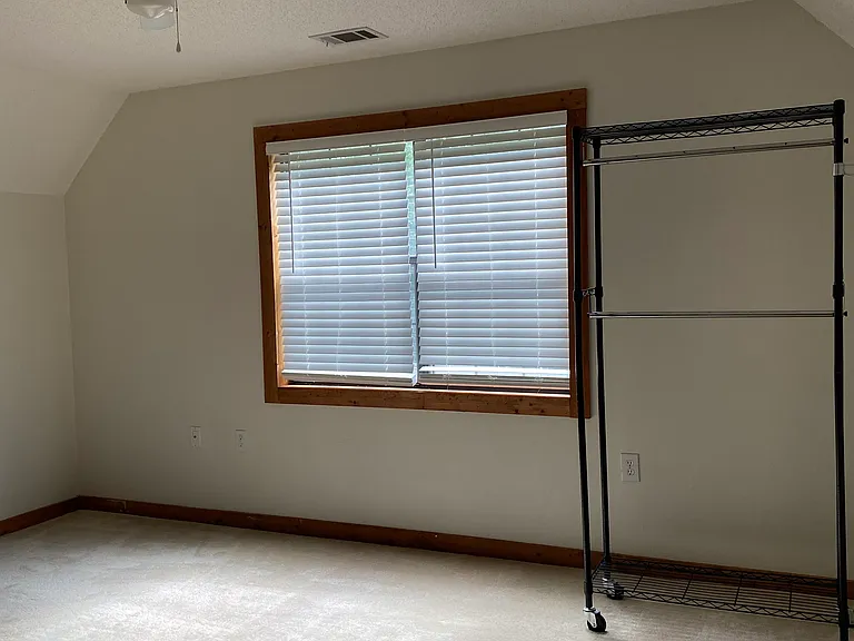 Removable rolling clothes/storage rack available for use in bedroom.