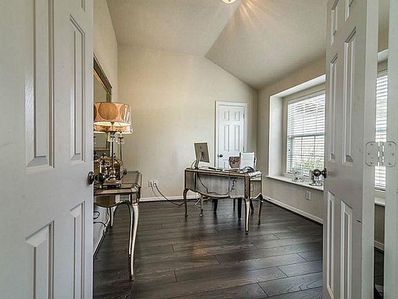 Through French doors is a wonderful home office with gorgeous laminate hardwood floors.
