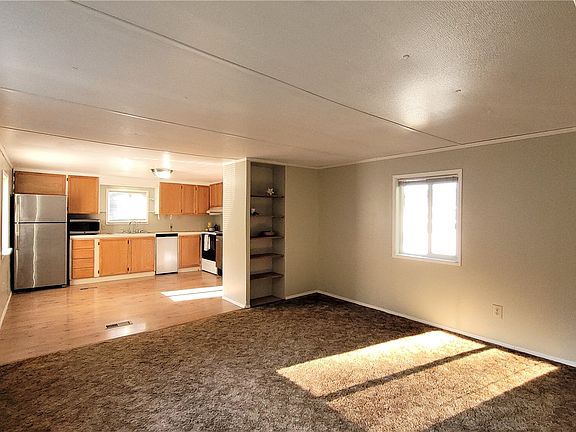Living room with easy access to kitchen & dining area, built in shelving and updated windows throughout>