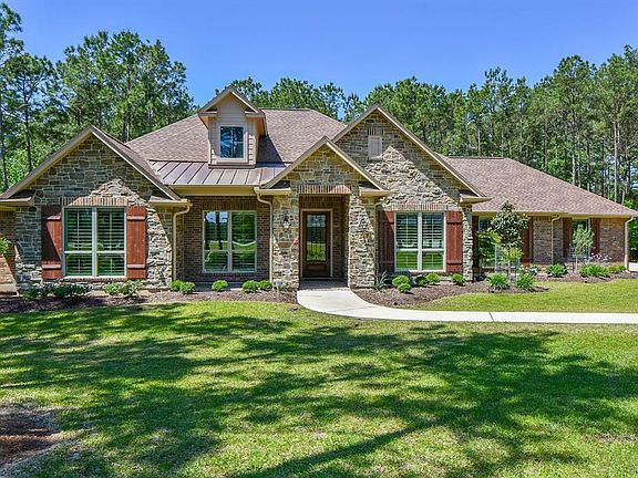 Brick and faux stone with dormer and standing seam metal roof accent over front porch area. Large front porch has pavers and sta