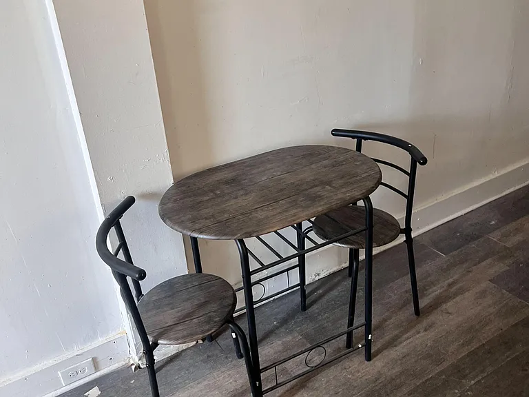 Compact dining nook with a bistro table and seating, set on durable plank-style flooring for easy everyday use.