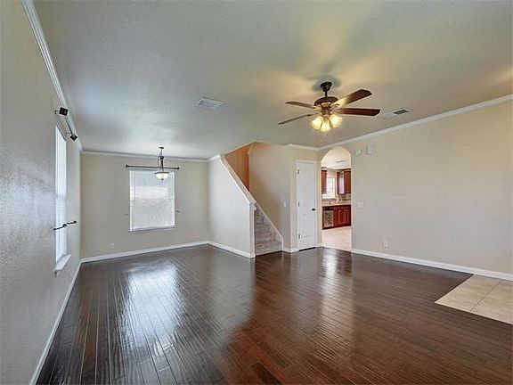 The living room has beautiful crown molding and a tile entryway.