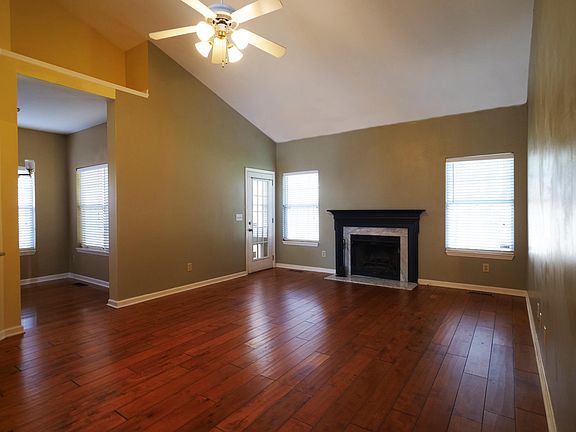 Great room with a wood-burning fireplace with a gas starter. In-kitchen dining area to the left.