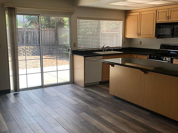 Spacious Family Room/Kitchen with Granite Counters, Center Island, Sliding Glass Door out to the Backyard, (Eat-In Dining area not shown in this Photo).