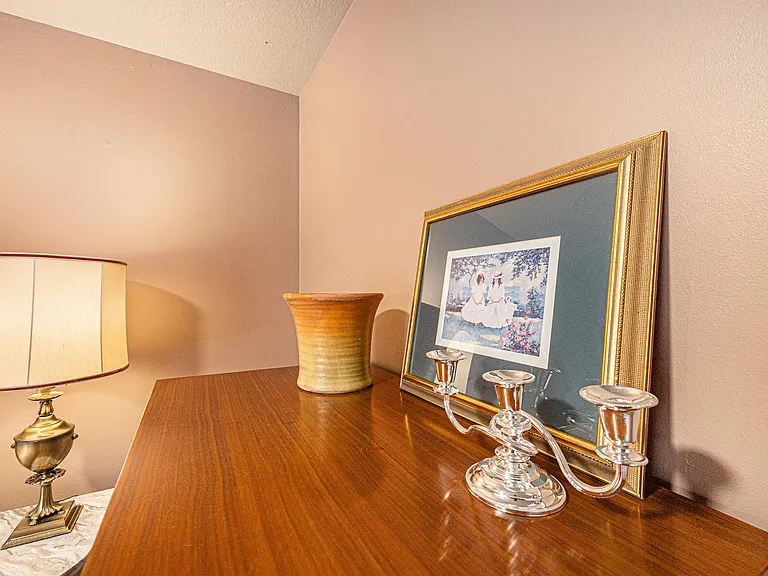Admire the curated cabinet top featuring artwork, a vase, and a candle holder, adding harmony and a refined touch to the space.