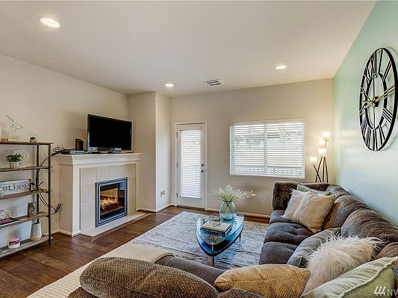 Living room with hardwood flooring, fireplace and entrance to balcony overlooking your fenced yard and open space