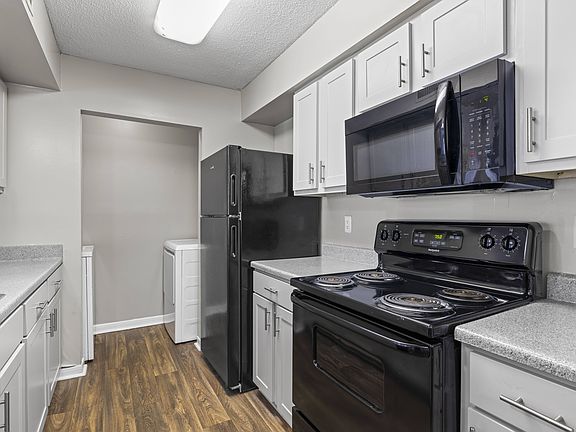 Well-appointed kitchens feature black refrigerator, stove, and white cabinetry, professionally operated by Highlands Vista Group.
