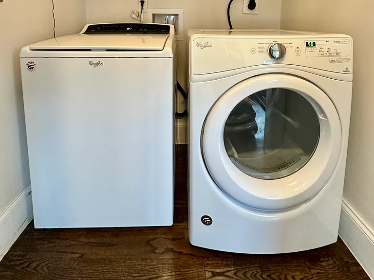 In-unit laundry with built-in overhead shelving, providing convenient extra storage for supplies, linens, and everyday household items.