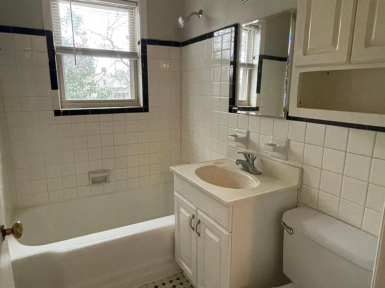 Cute bathroom with black and white tiled floors. Another window to let in natural light.