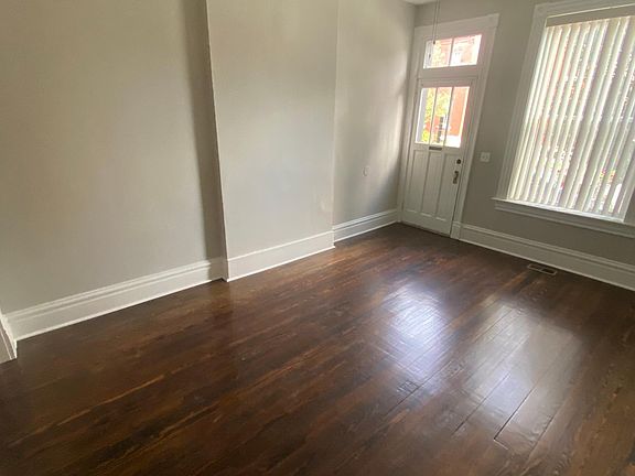Living room, dark finish hard floors, ceiling fan. Good natural light