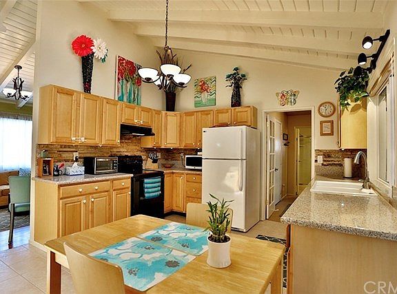 Gorgeous kitchen with granite counter tops, travertine tile, maple cabinets, high wood beam ceilings