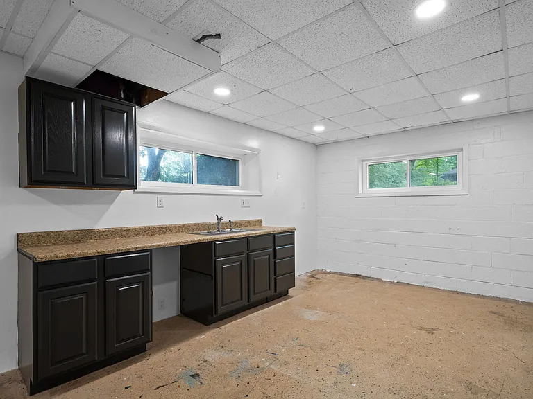 Garage / Laundry located downstairs with a sink and folding station set up.