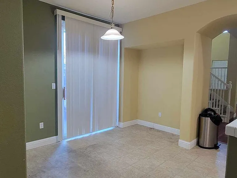 Breakfast nook next to kitchen with sliding glass door side entrance to driveway and door to garage (on left, not shown)