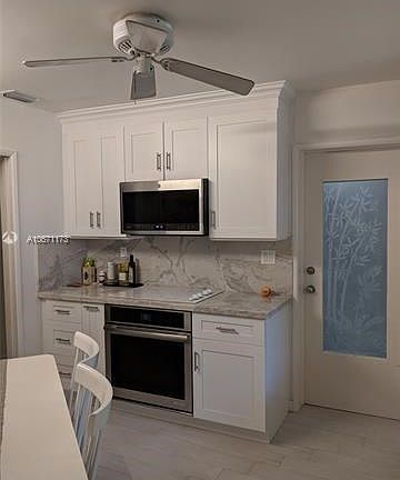 The etched door to garage is to the right and the doorway to the left is the hallway leading to the Livingrm/Diningrm! Notice the full GE Micro-wave and the off-white light color of the Whirlpool Cook-top matches the color the Breccia Pearl Soft Quartzite