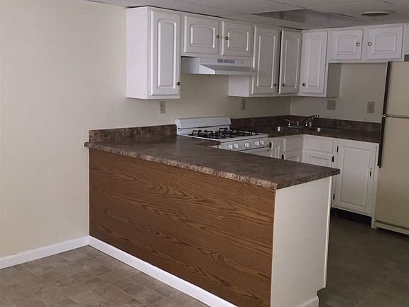 Bar-style kitchen opens to living area.