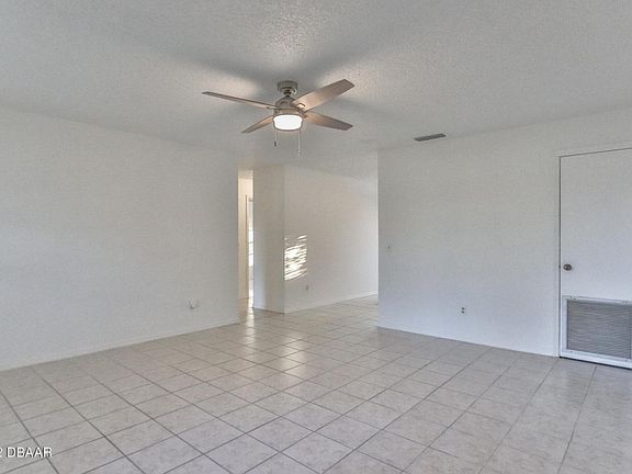 Large tiled living room leads to kitchen and bedrooms