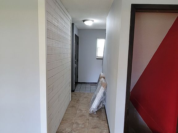This is a photo from the living room facing the front door and showing both the hallway and the basement stairs to the right.