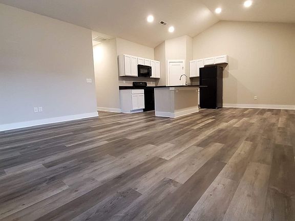 Large open space with a granite center island and corner walk-in pantry