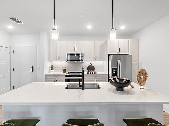 Kitchen island with Quartz Countertops and overhead pendant lighting