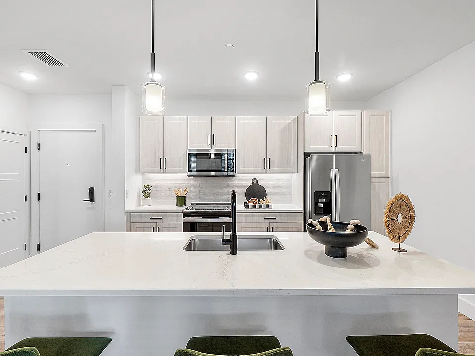 Kitchen island with Quartz Countertops and overhead pendant lighting
