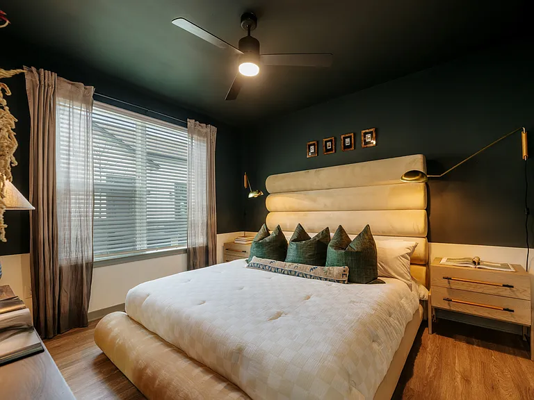 Stylish secondary bedroom with designer finishes, warm wood-inspired flooring, and oversized windows for natural light.
