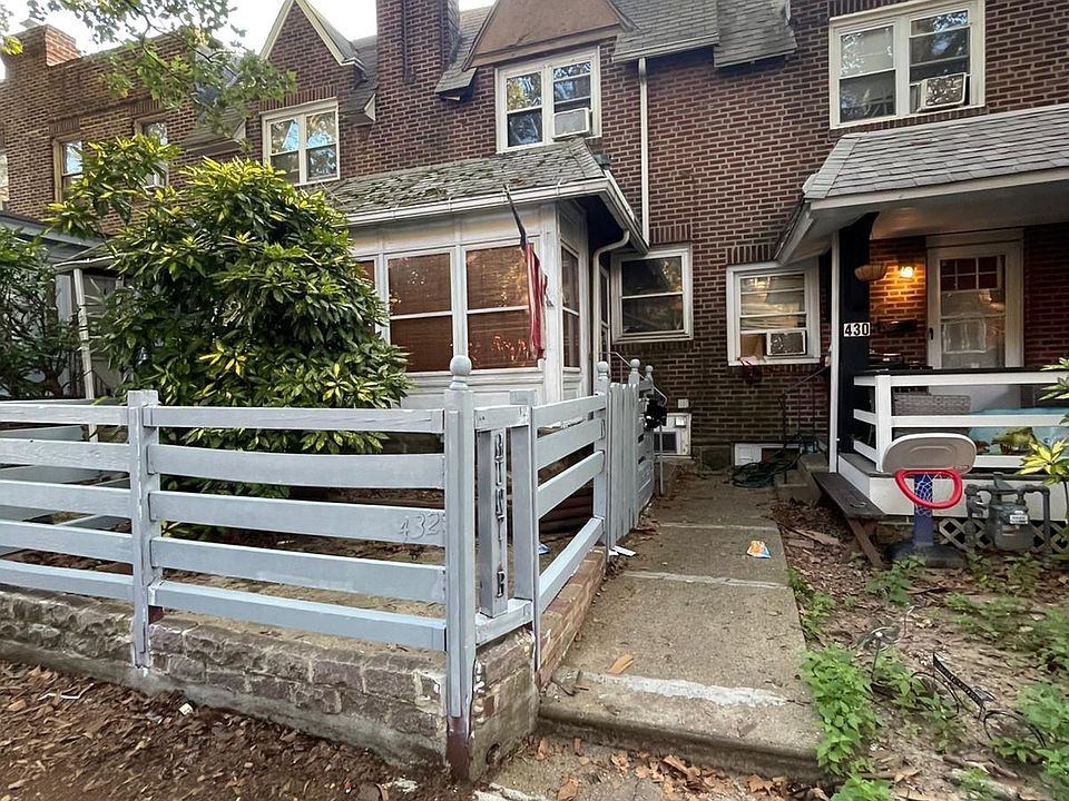 House on the left with fenced front area and enclosed sunroom / mudroom.