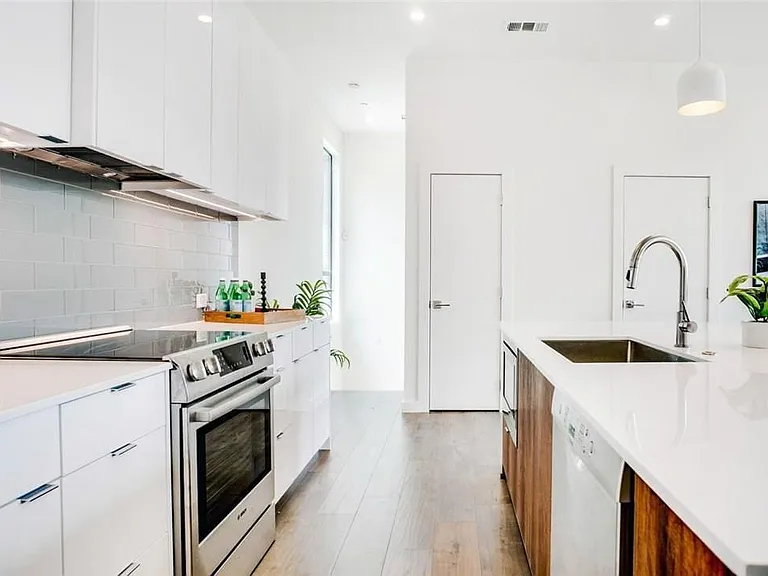 Modern kitchen featuring a white subway tile backsplash and stainless steel appliances