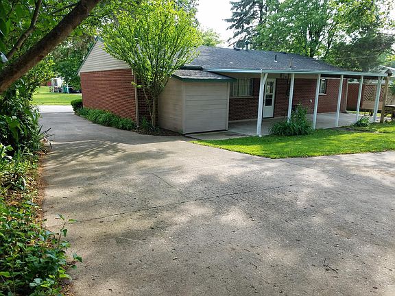 Large covered concrete patio with small storage shed off kit