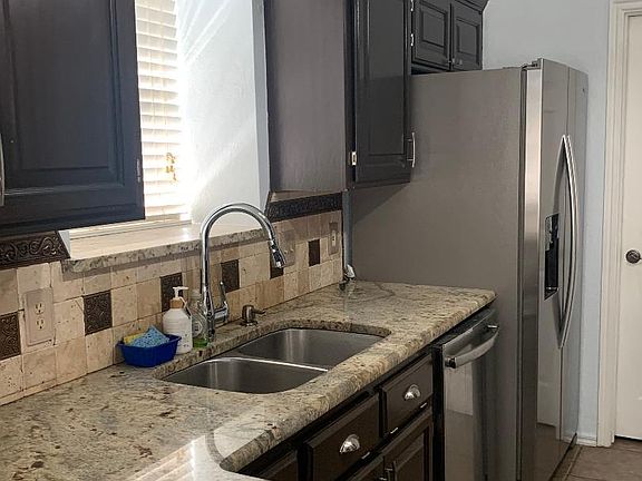 Granite counter tops, double stainless steel sink, appliances include refrigerator, microwave, gas range, dishwasher.