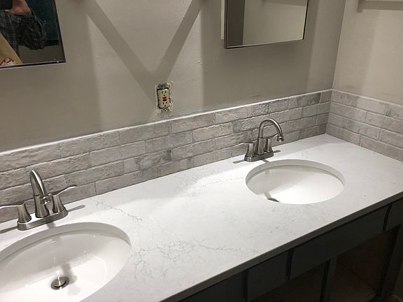Bathroom - Quartz countertop, tile backsplash, satin finish faucets, duel under mount sinks.