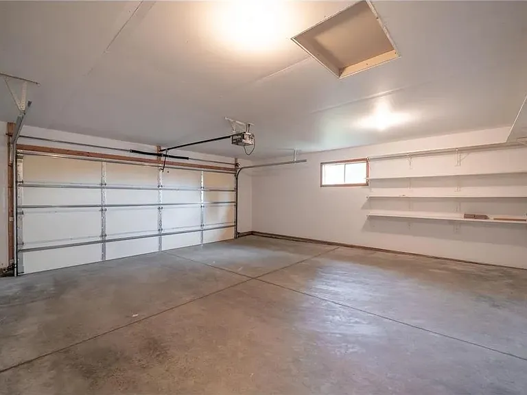 Oversized 2-Stall Garage with lots of Storage Shelving, Exterior Service Door, and Opener with Keypad