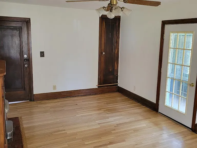 Livingroom leading to private front entrance, closet, and door leading to carpeted porch.