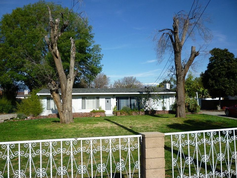 Fenced front of house from street. 2 driveways left and right side of house.