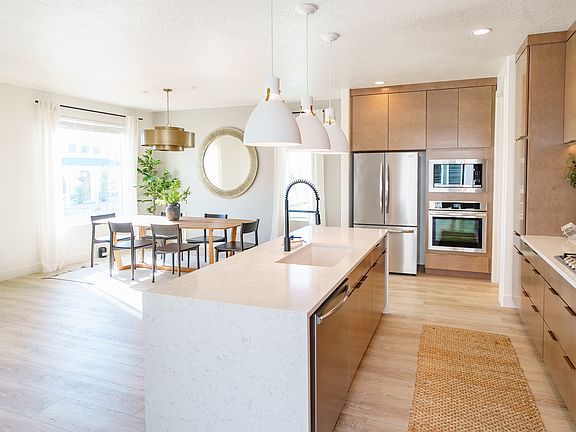 Bright modern kitchen from the Contempo Collection with an island, white countertops, wood cabinets,