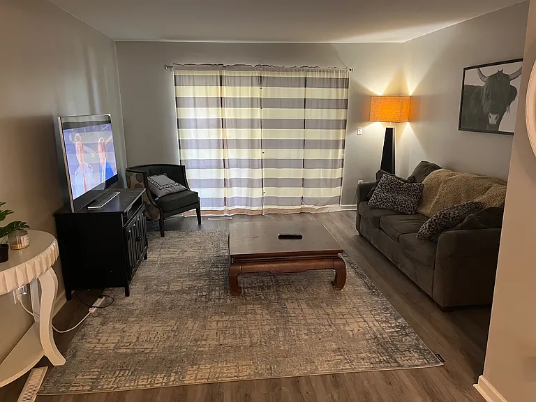 Spacious family room with a large sliding glass door, exiting to the outdoor stamped patio with bench swing.