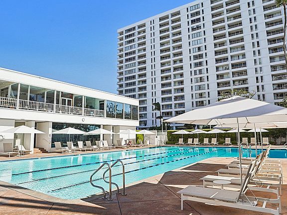 Heated Jr. Olympic size pool with plenty of seating and umbrellas
