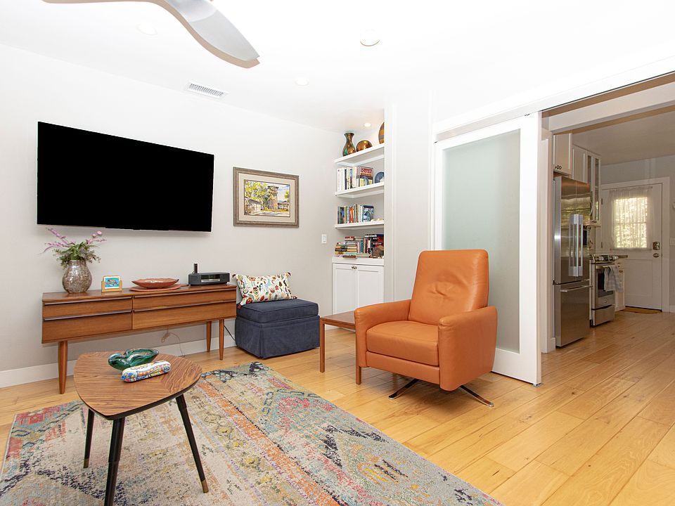 American Leather reclining easy chair, antique Danish credenza. Natural hickory flooring, recessed lighting, sliding doors allow room to be closed off to create a private bedroom. Free-weight set in built-in cabinet.