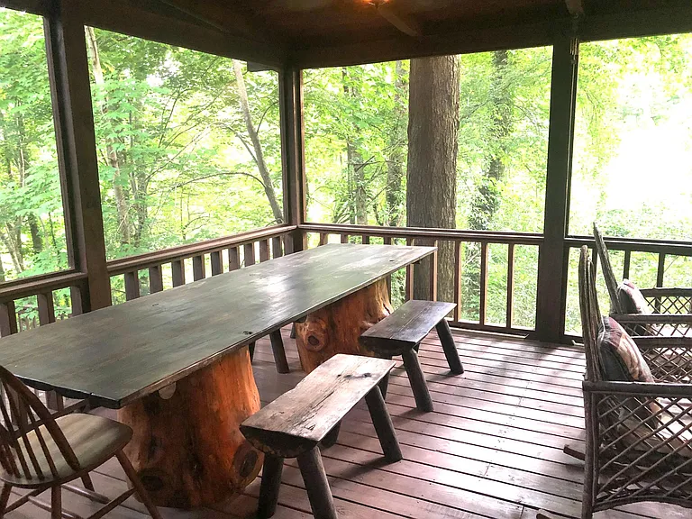Oversized table on back screened-in porch.