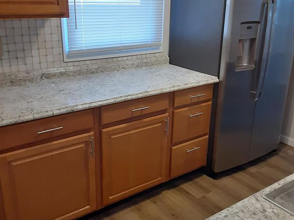 Galley kitchen with new cabinets and flooring. New stainless steel side-by-side refrigerator. plenty of counter space