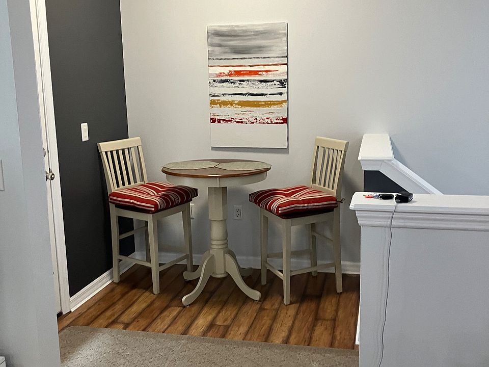 Small cafe table at top of stairs, off kitchen, near front porch.
