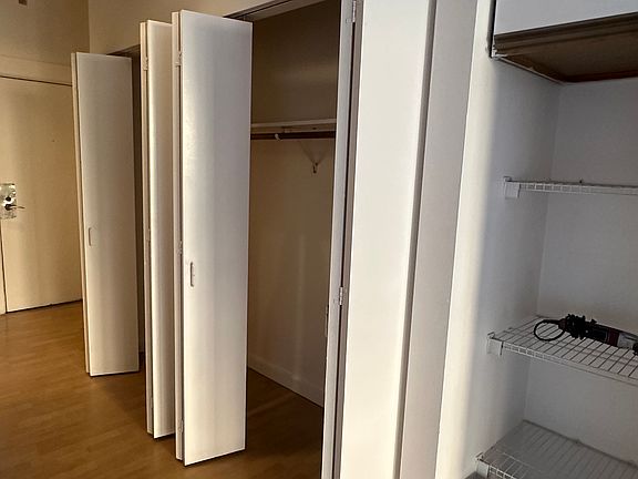 Hallway with abundant shelving and entryway