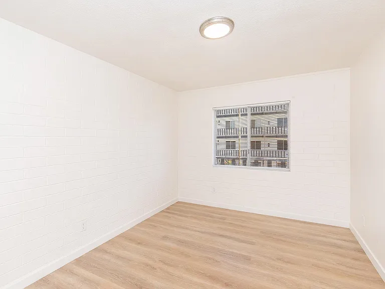 Room with light wood flooring and large window