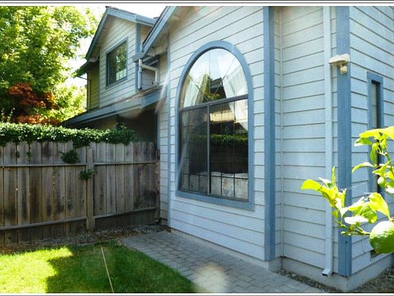 Large living room picture window in fenced front yard