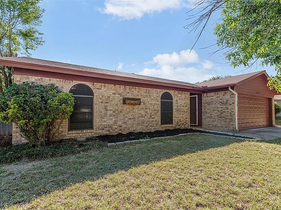 Single story home featuring a garage and a front lawn