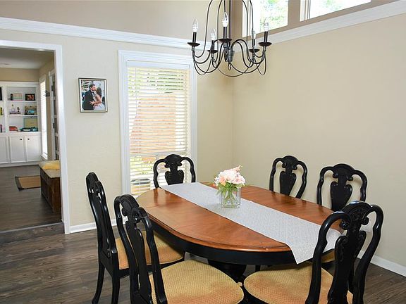 Formal dining room with gorgeous chandelier. Lots of natural light with high windows.