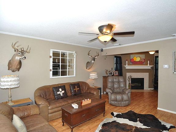 LIVING AREA W/ LAMINATE FLOORING, NEUTRAL PAINT, CROWN MOULDING, AND UPGRADED FAN