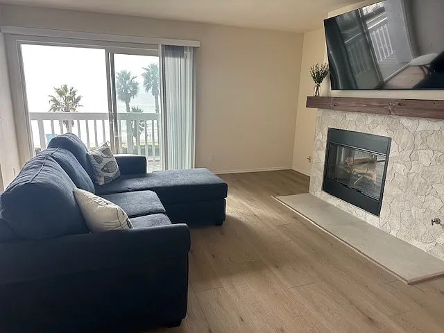 Natural stone gas fireplace in living room . Listen to the waves through your patio doors.