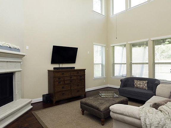 The gorgeous hardwoods extend into the family room which also boasts high ceiling, natural light and a cast stone fireplace.