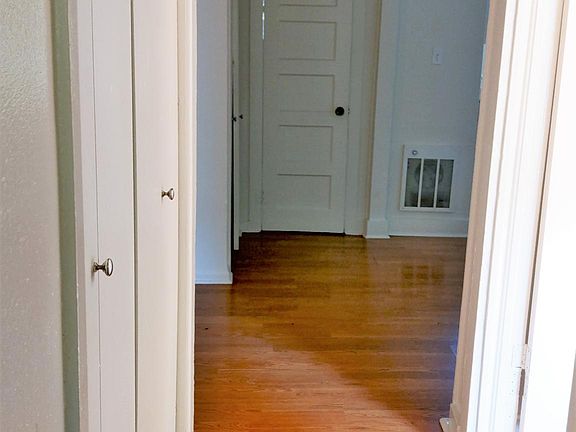 View from front door to the bathroom door at the end of the hallway. The bedroom is the entrance on the right and the bedroom closets can be seen on the left.