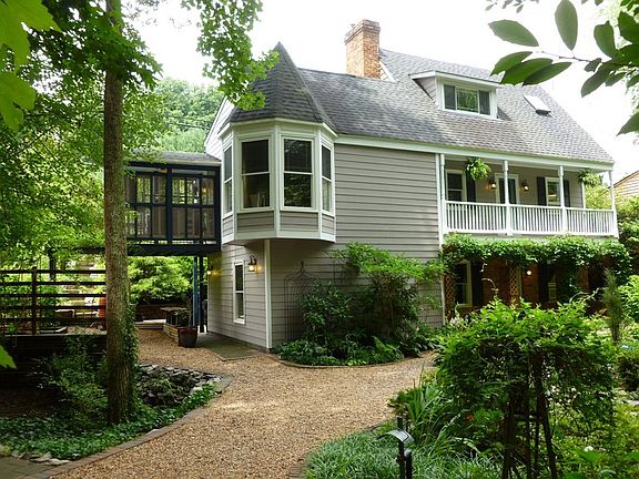 House front from driveway.
						:
						Shows turret window and 2nd floor veranda over front porch and entrance.